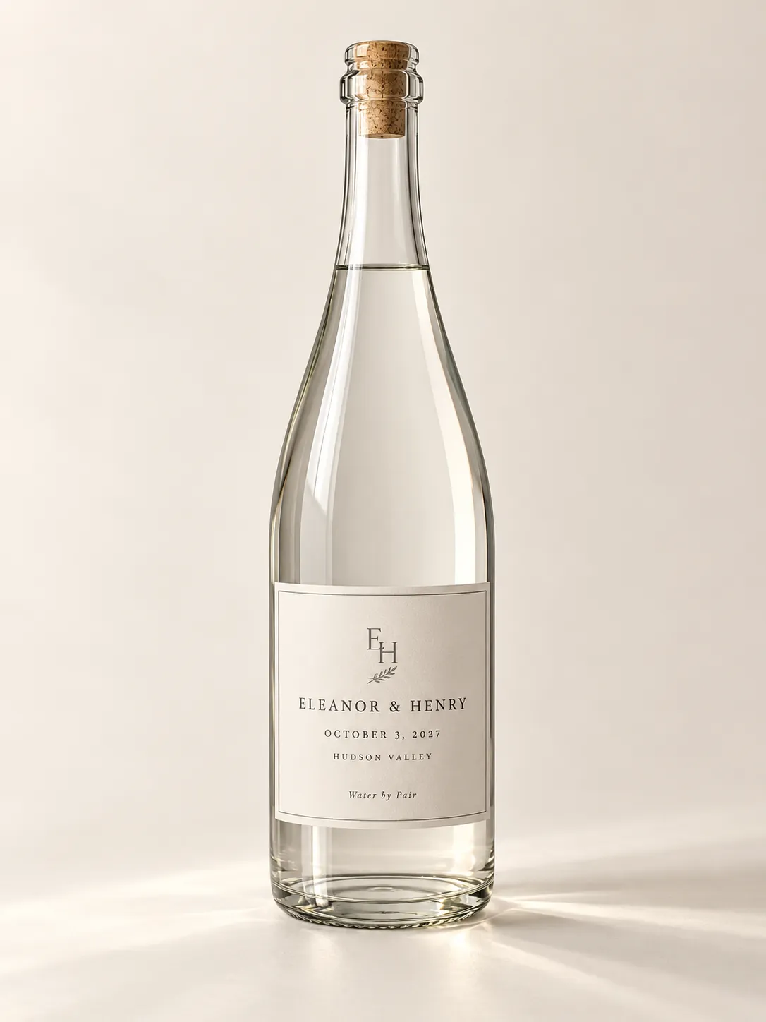 Classic concept bottle with a warm ivory label, a monogram, and formal serif. The names are illustrative.